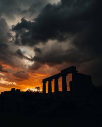 A strong, moody style photograph captures intense dramatic weather and low contrast, with stormy skies looming over ancient s