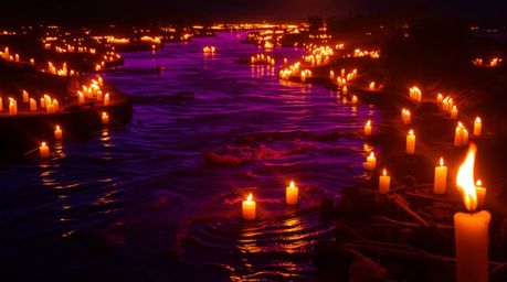 A captivating scene of a river delta bathed in the vibrant colors of twilight.  Illuminated by flickering candlelight, the wa