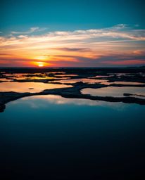 A professional photograph, reminiscent of Associated Press and editorial photography, captures a cool-toned sunset sky—featur