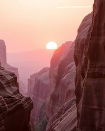 A high-resolution stock photo of commercial quality captures a sunset illuminating sandstone cliffs in a canyon. The scene is