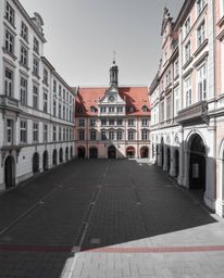 A precise architectural color photograph capturing an empty town square characterized by sharp lines, detailed structures, an