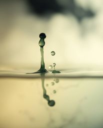 A captivating macro photograph showcasing a soft, dreamy ink splash in water.  The image features a hazy background, soft lig