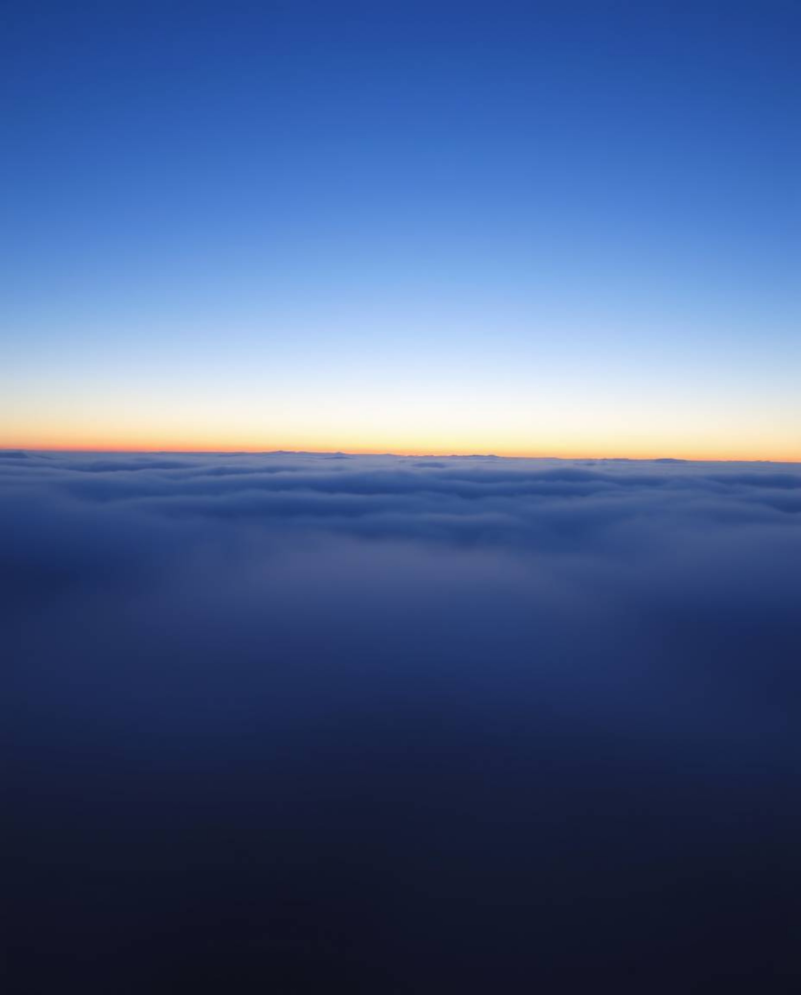 Witness a high-contrast sunset from a high alpine peak, where low visibility and thick fog create a mysterious and atmospheri