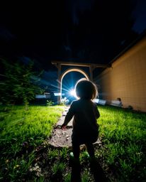 A captivating long exposure photograph depicts a child's wondrous discovery of a magical portal in their backyard. The image