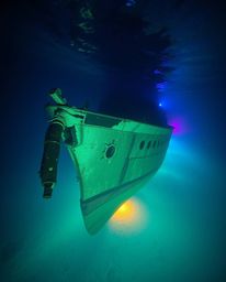 Discover a breathtaking underwater shipwreck scene, bathed in electric vivid colors and soft, diffused light.  Explore the vi