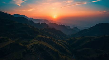 Capture the breathtaking beauty of a sunset over mountainous rice terraces with this high-resolution stock photo. Featuring a