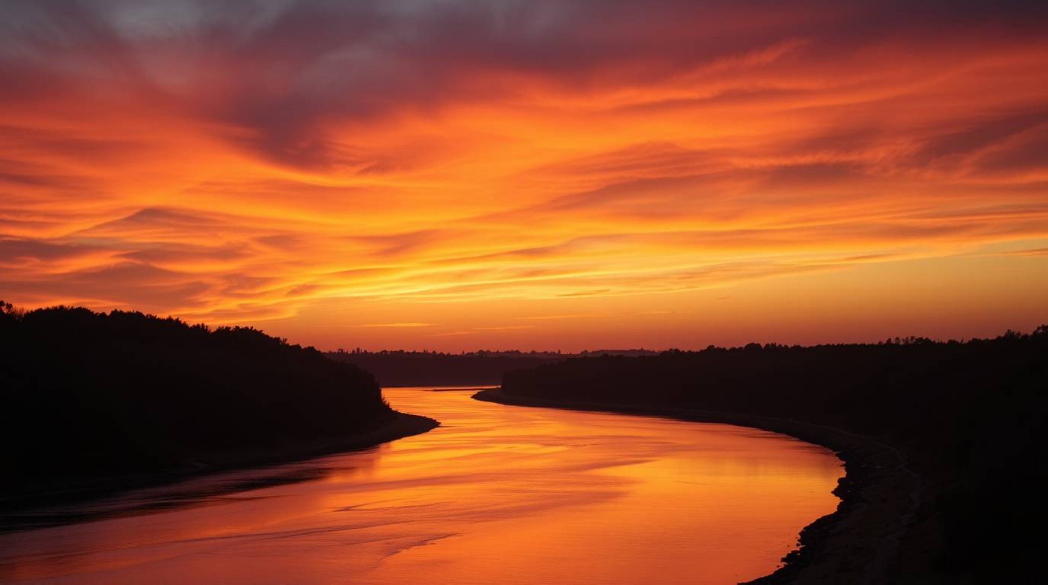 This stunning fine art photograph captures a winding river bathed in the warm glow of a dramatic orange-pink sunset.  Profess