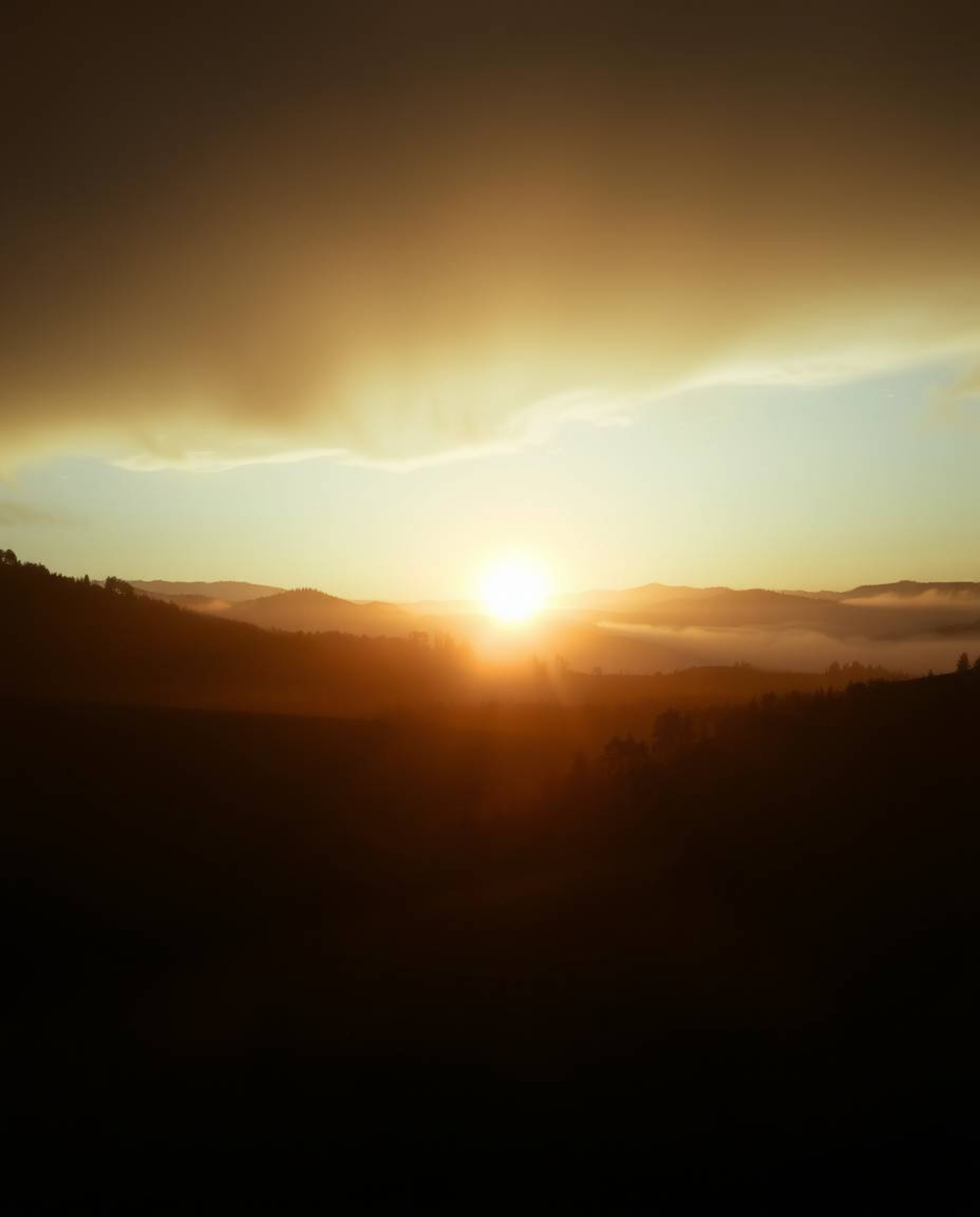 Volumetric lighting illuminates a mystical sunset over misty Tuscan hills, creating an ethereal spiritual vibe with visible l