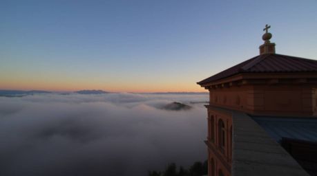 This architectural color photograph captures the serene beauty of fog-covered hills at sunset.  Featuring a sharp focus on th