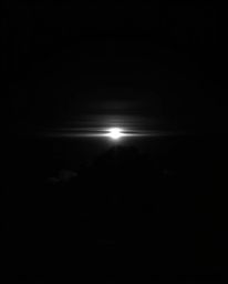 This is a high-contrast black and white photograph depicting a moody sunset from a high alpine peak. The composition uses low