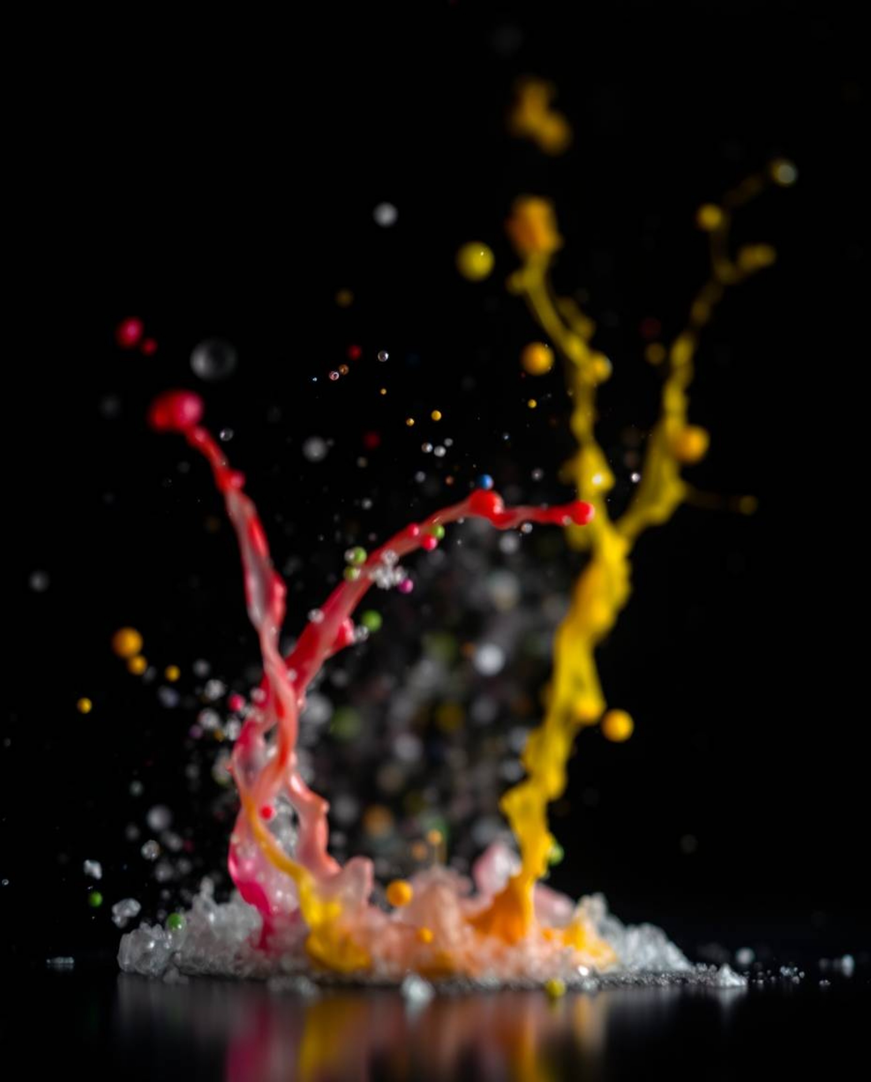 This captivating photograph features dynamic and vibrant colorful splashes frozen in time against a stark black background. U