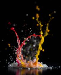 This captivating photograph features dynamic and vibrant colorful splashes frozen in time against a stark black background. U