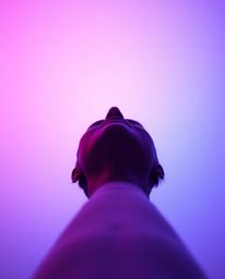 A captivating low-angle shot showcases a soft gradient blending pink, blue, and violet hues against a minimal backdrop.  The 