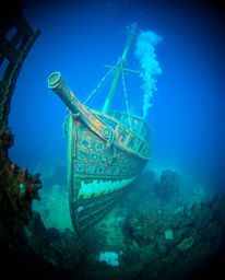 A captivating close-up reveals a vibrant underwater shipwreck, bathed in electric hues. This stunning image, perfect for Inst