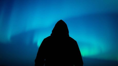 This image captures a cool-colored, eerie atmosphere with a silhouetted figure standing against a gradient texture inspired b
