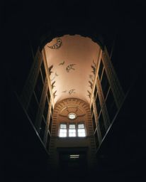 Discover a captivating low-angle perspective of a magical school, bathed in dramatic chiaroscuro lighting.  The image feature