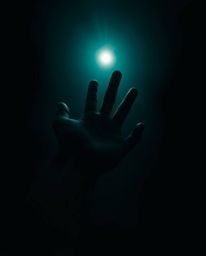 This image captures a hand reaching towards light from the depths of darkness, rendered in a rich and deep teal color palette