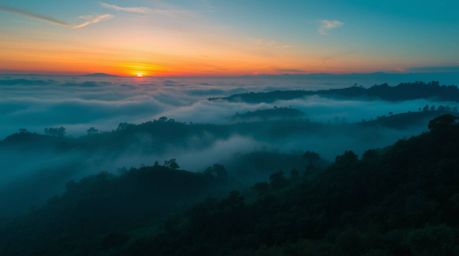 Capture the essence of professional photography with rich, deep teal tones and fog-covered hills illuminated by a breathtakin