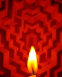 A tight close-up shot featuring warm candlelight illuminating a repetitive Escher-style impossible cube pattern. The flickeri