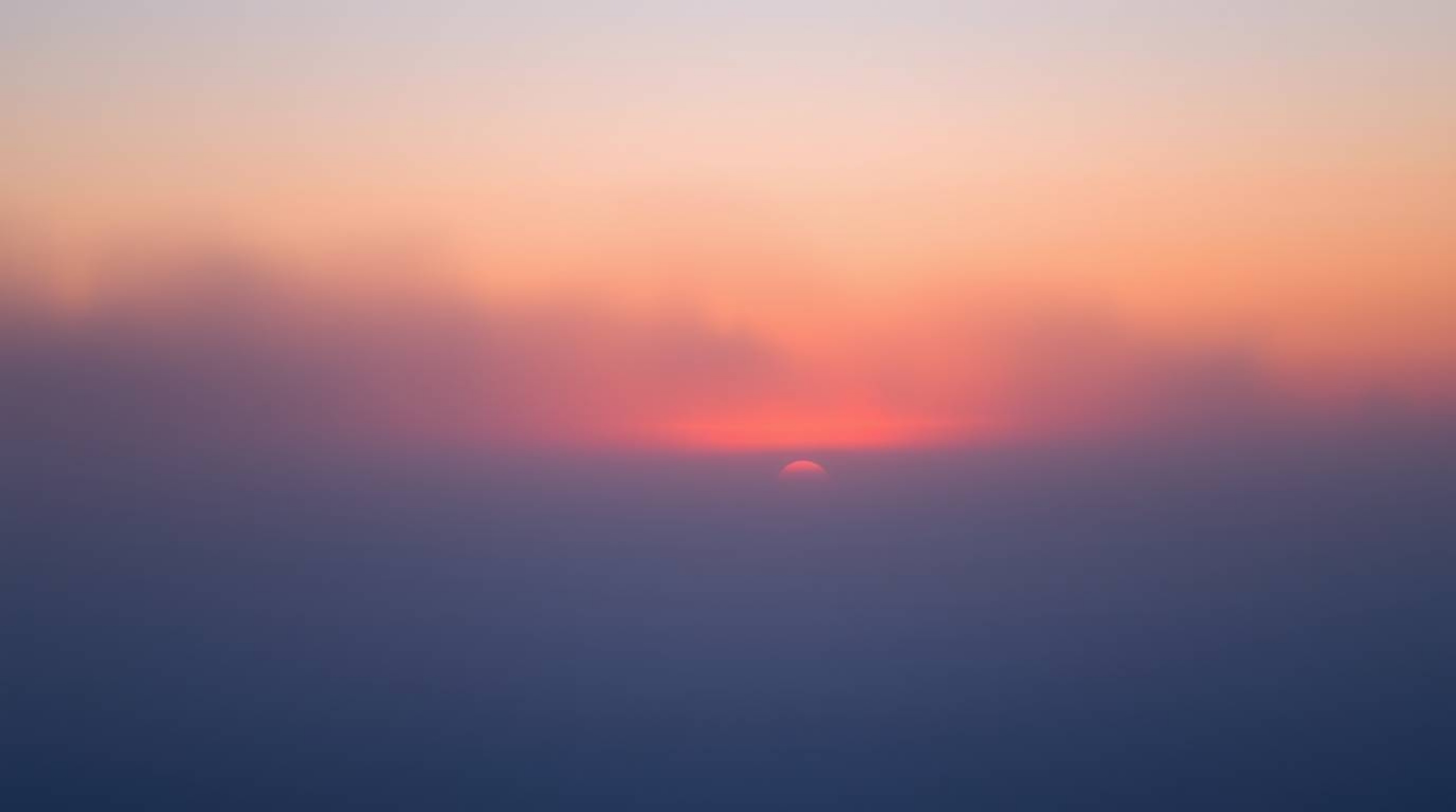 Witness the ethereal beauty of the Northern Lights subtly emerging from a thick fog over a breathtaking sunset sky.  This cap