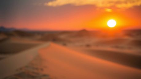 Experience the breathtaking beauty of a dramatic sunset at the edge of a desert, where golden dunes meet a fiery sky. This im