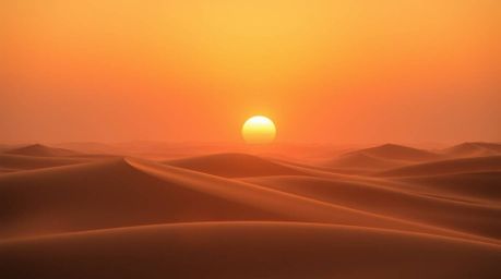 A stunning fine art photograph depicting a serene sunset over golden desert dunes.  The image features warm, soft lighting wi