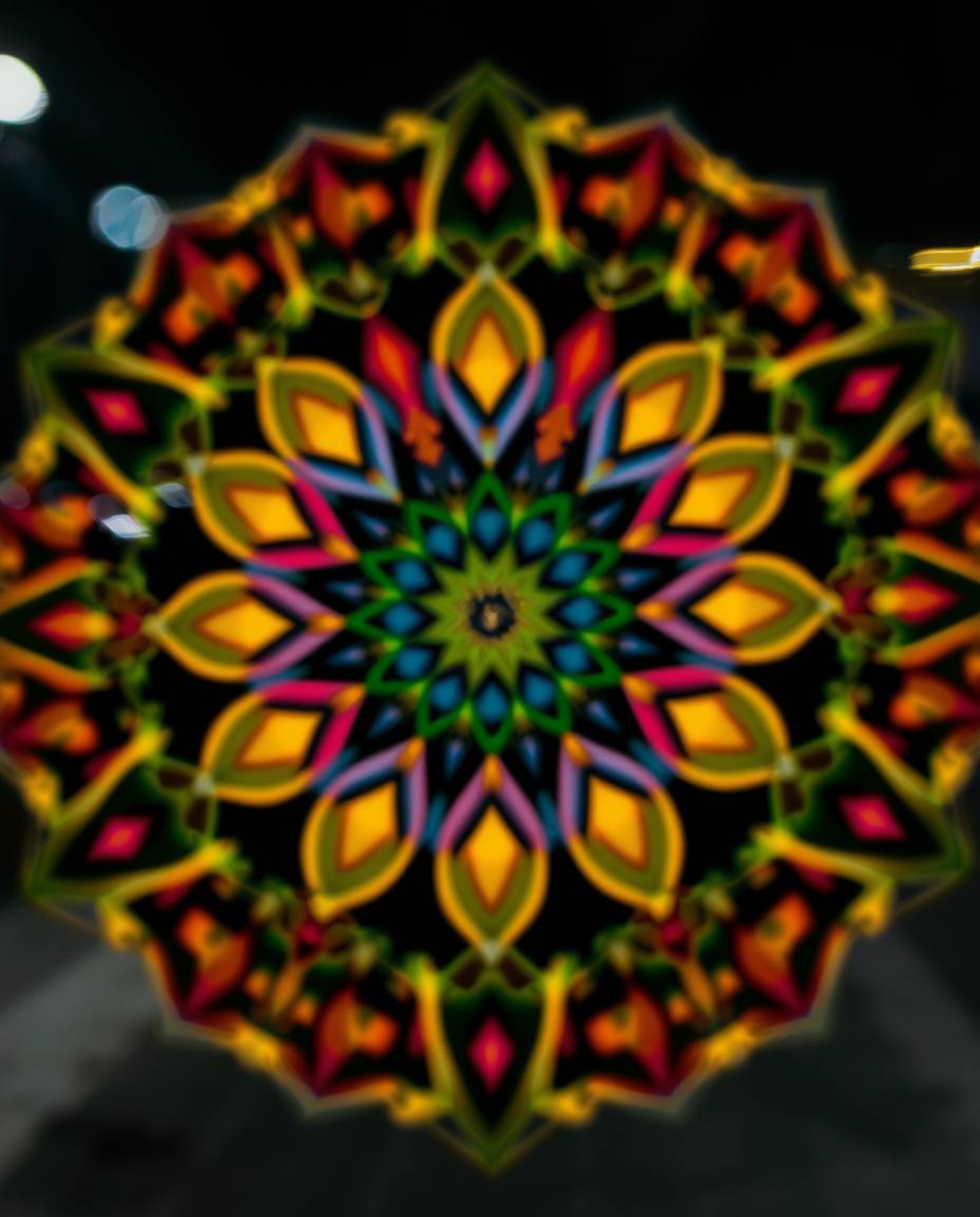 A captivating long exposure photograph showcasing a geometric floral mandala with a mesmerizing blurred bokeh effect. The ima