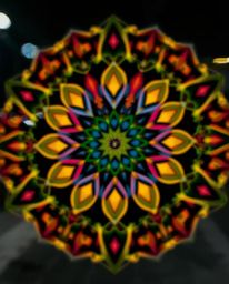 A captivating long exposure photograph showcasing a geometric floral mandala with a mesmerizing blurred bokeh effect. The ima