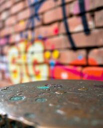 Discover stunning bronze sculptures featuring a captivating blend of graffiti-style colorful splashes on a brick wall.  The i
