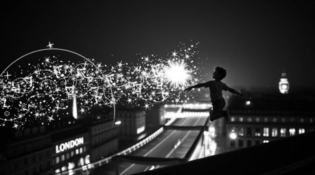 A timeless and elegant black and white image showcasing a young boy flying above London with pixie dust, incorporating artist