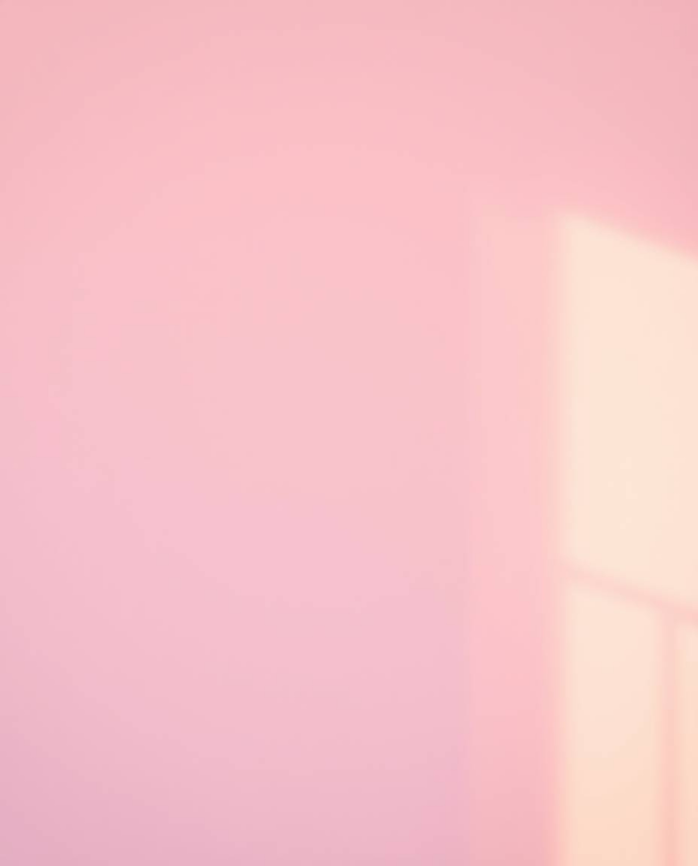 A stunning professional photograph bathed in the warm glow of golden hour light.  Soft, gradient textures blend delicate pink