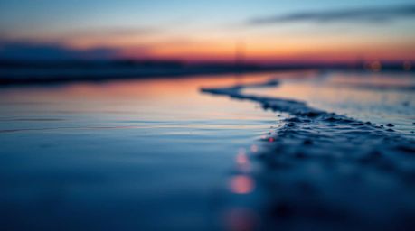 A stunning extreme macro close-up photograph depicts a river delta bathed in the soft glow of twilight.  Rendered in a modern