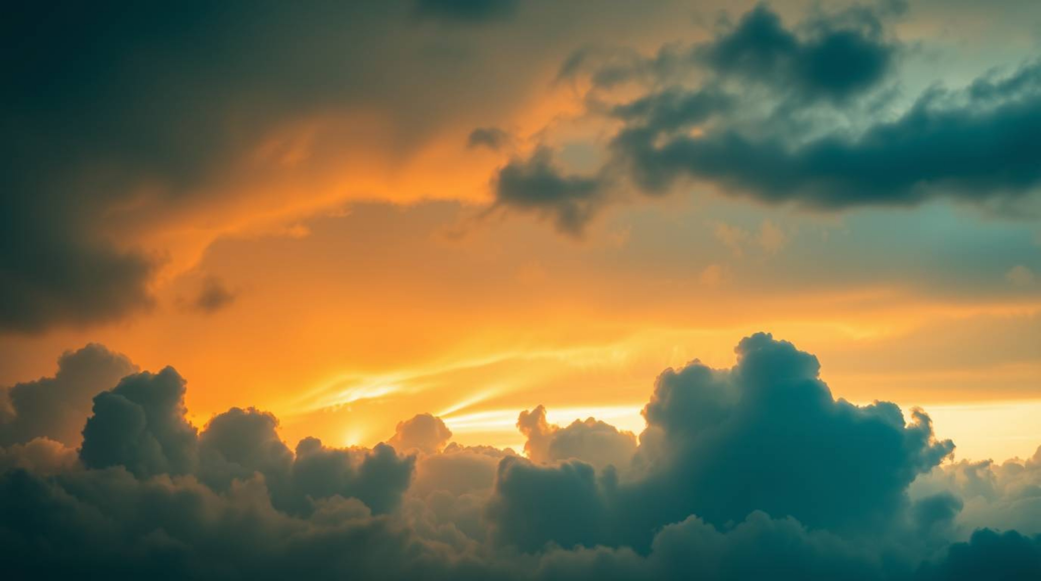 Experience the dreamy atmosphere of a vibrant sunset illuminating deep teal thunderstorm clouds.  This image evokes a feeling