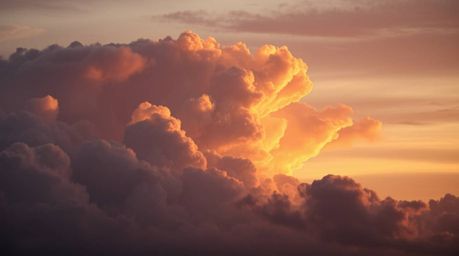 A captivating close-up shot reveals the mesmerizing beauty of thunderstorm clouds illuminated by the warm hues of a setting s