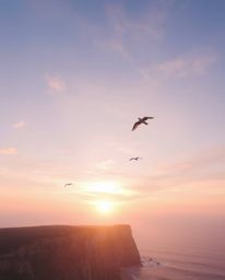 This is an ethereal and spiritual depiction of a sunset over a coastal cliff, complete with soaring birds. The scene is rende