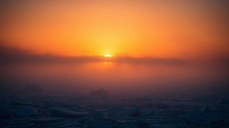 This fine art photograph captures a breathtaking sunset over icy polar glaciers. The image utilizes warm, soft, and dark tone