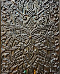 An overhead view captures the beauty of a cast bronze surface adorned with intricately carved Islamic geometric patterns. The