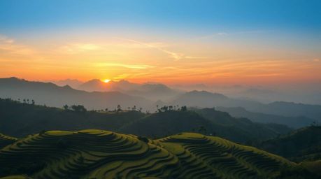 A graceful fine art photograph capturing a sunset over rice terraces in the mountains. The image exhibits refined features wi