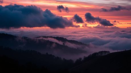 Experience the captivating beauty of fog-covered hills bathed in the warm hues of sunset, as stormy skies add a dramatic touc