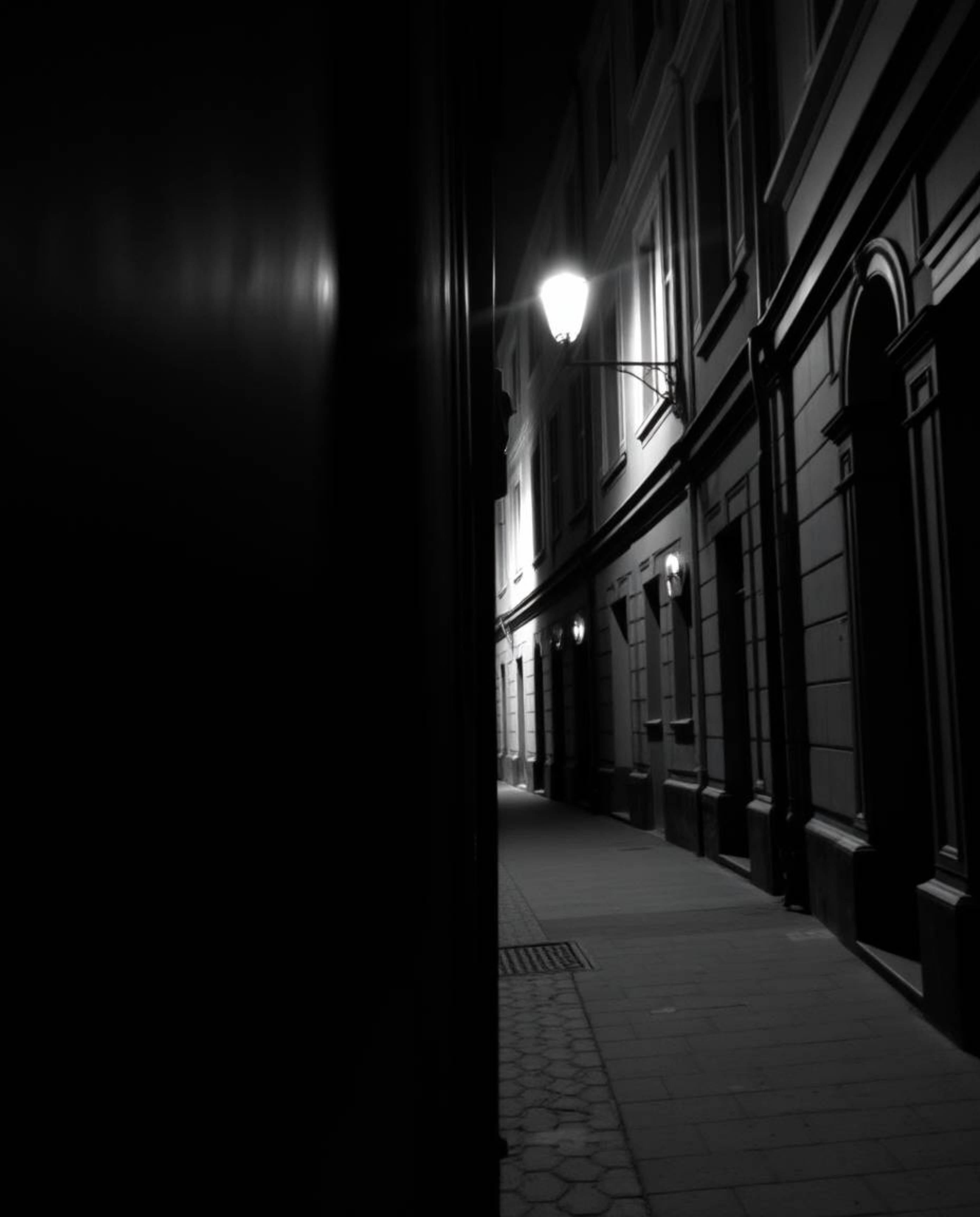 A captivating black and white architectural photograph capturing a timeless scene. Eyes seem to watch from the shadows of a d