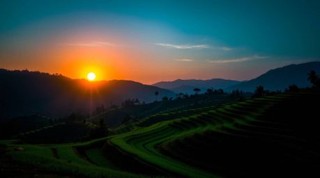 Experience the breathtaking beauty of a sunset over rice terraces, dramatically illuminated with cool color chiaroscuro light