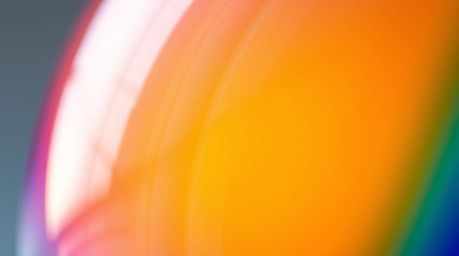 A captivating close-up showcasing a glass object reflecting smooth, gradient textures. The image bursts with vibrant compleme