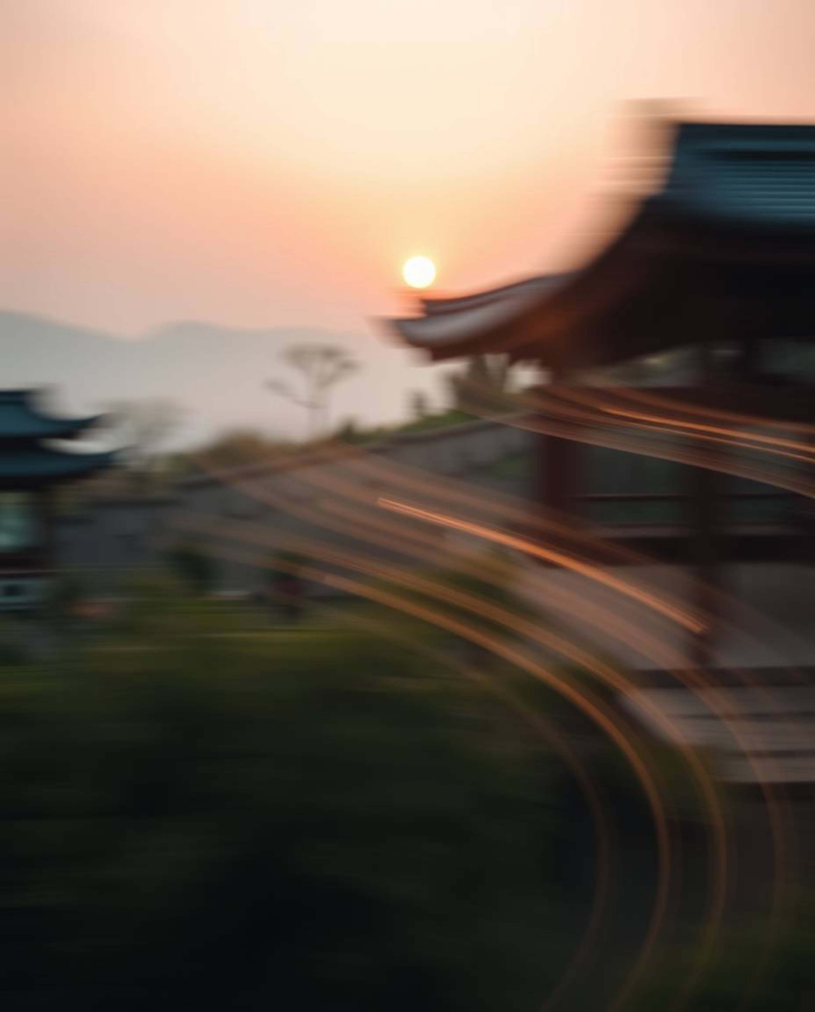 Witness an ethereal long-exposure photograph of a serene Zen garden at sunset. This captivating image features artistic motio