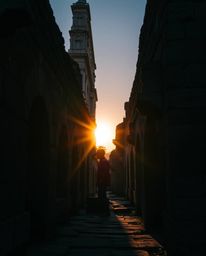 Precise architectural color photography depicting a sunset casting shadows through ancient stone ruins. This image utilizes n