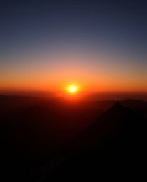 Witness a high-contrast, low-key lit sunset from the stunning vantage point of a high alpine peak. This composition is both g