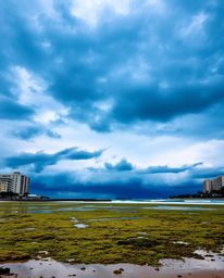 This piece, in a candid street photography style, captures an urban scene under intense, dramatic weather. It depicts a spont