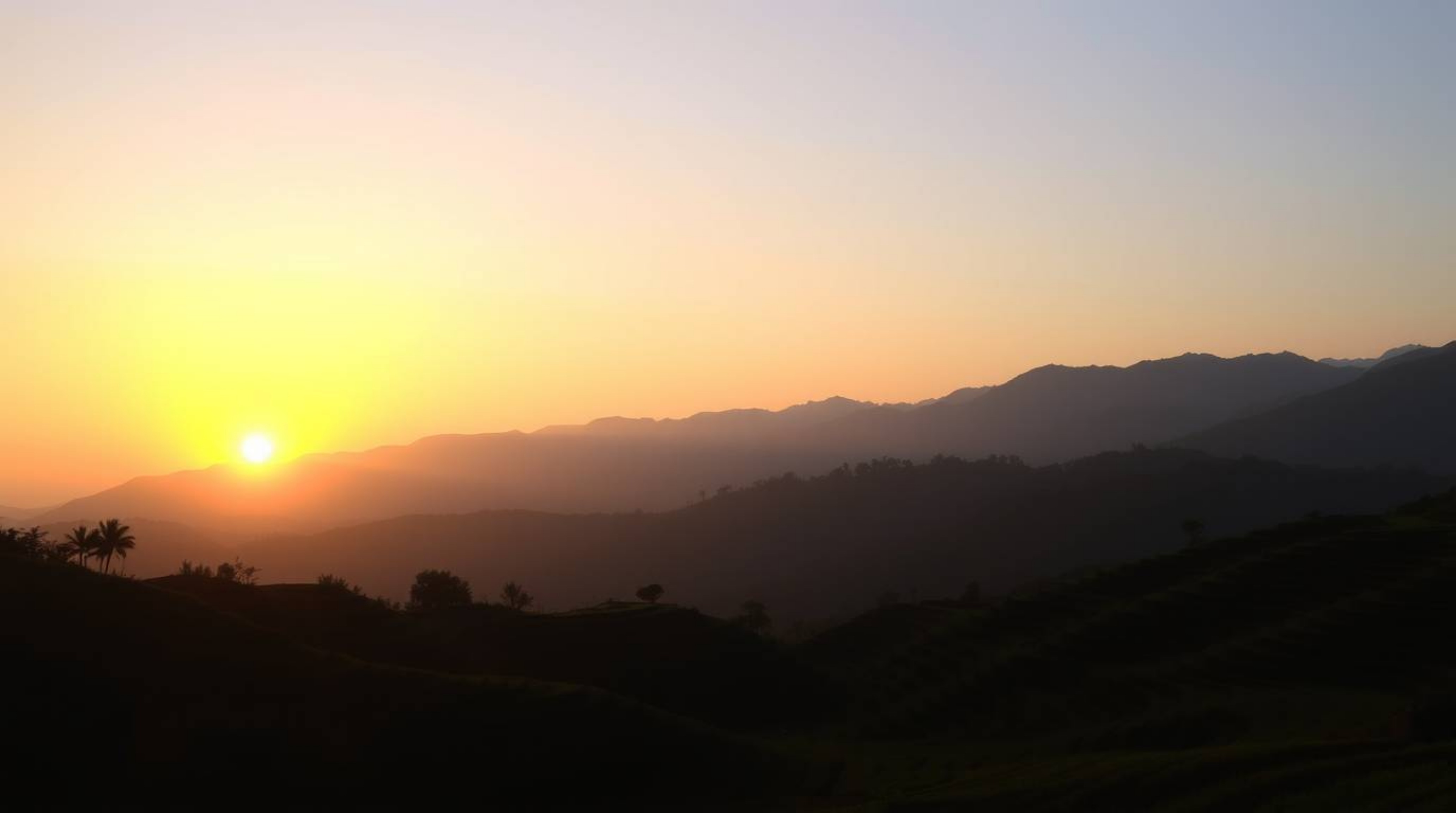 Witness the breathtaking beauty of silhouetted rice terraces nestled in the mountains against a vibrant sunset. This captivat