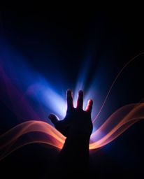 This image showcases creative light art with a hand reaching toward light from darkness, featuring artistic lighting and abst