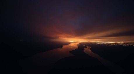 Experience the intense drama of a river delta bathed in the ethereal glow of twilight. Captured from a low-angle perspective 
