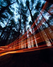 A captivating long-exposure photograph reveals a digital glitch-affected forest scene, showcasing dramatic light trails and a